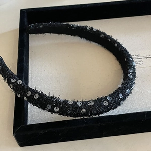 Close-up of French style black sequined headband with sparkling silver details