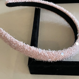 French style light pink sequin headband with soft plush texture on a black stand