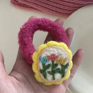 Handmade pink wool felt hair tie with sunflower embroidery and soft plush texture