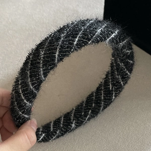 Detail of black tweed headband with white plaid texture and subtle silver glitter
