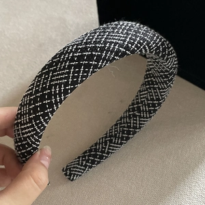 Close-up of black and white checkered tweed headband with padded sponge design