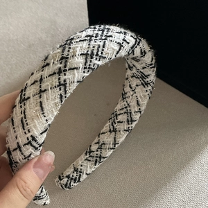 Detailed close-up of the black and white plaid tweed headband with gold metallic threads