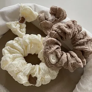Detailed view of beige and brown bubble fabric scrunchies with cute bear patches