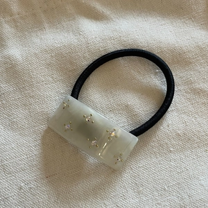 Sparkling diamond acetate cube hair tie with marble texture on elastic black rubber band