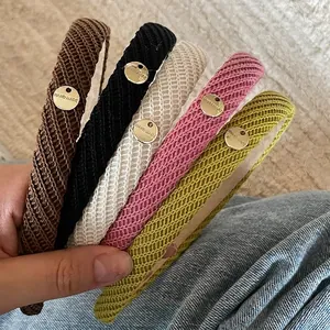 Set of five handmade knitted headbands in brown, black, cream, pink, and green colors