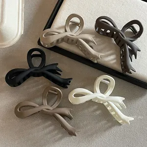 Détail de pinces à cheveux noeud mat en cinq couleurs dont beige, marron et noir