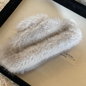 Detailansicht der großen Plüsch-Haarklammer in Hellbeige aus weichem Kunstfell in Tablett