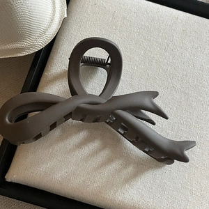 Gros plan sur la pince à cheveux nœud marron foncé mat montrant la texture givrée