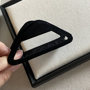 Détail de la pince à cheveux triangulaire noire avec texture velours et dents solides