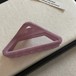 Gros plan détaillé d'une pince à cheveux triangulaire floquée violette sur toile