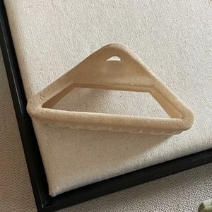Gros plan sur la pince à cheveux triangulaire floquée beige avec texture velours