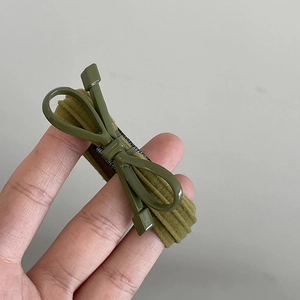 Gros plan détaillé d'un accessoire à cheveux nœud vert olive à texture côtelée