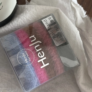 Macro shot of colorful plush hair bands set in a clear square gift box packaging