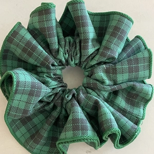 Close-up of green and black plaid scrunchie with detailed fabric texture and stitching