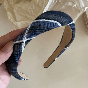 Detail of blue and black plaid headband with decorative white contrast stitching