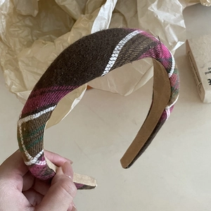 Detailed macro view of the retro pink checkered headband with white wavy stitch accents