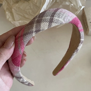 Detail view of the pink and white plaid pattern on the padded wide headband fabric