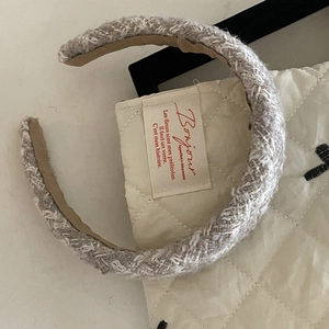 Close-up of French vintage tweed headband in beige and white on a quilted bag