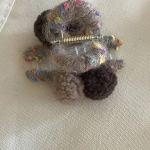 Pince à cheveux boules en laine d'agneau marron avec ressort doré sur toile