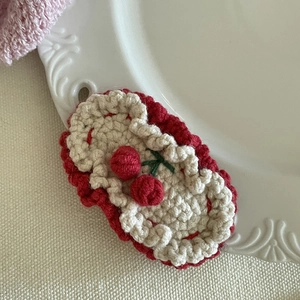 Gros plan sur une barrette en crochet faite main avec cerises rouges et feuilles vertes