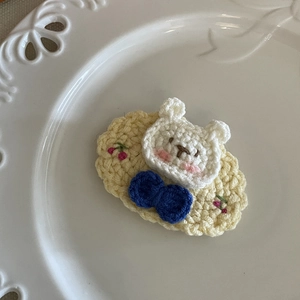 Détail d'une barrette au crochet avec ours mignon, nœud bleu et petites cerises