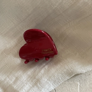 Detail of red acetate hair claw clip showing gold France Handmade lettering