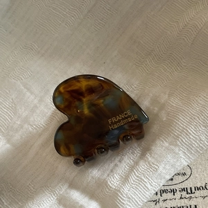 Detail of a handmade heart-shaped tortoiseshell acetate hair claw with gold logo