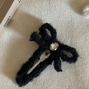 Barrette à cheveux nœud en peluche noire avec strass et détail d'étiquette dorée