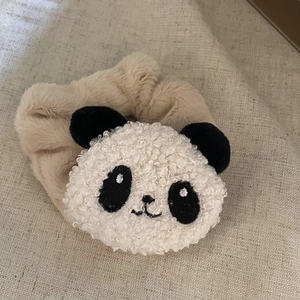 Détail d'un chouchou panda mignon en polaire peluche beige avec texture douce