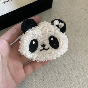 Détail de la pince à cheveux panda en peluche avec perle et décor en cristal de cœur