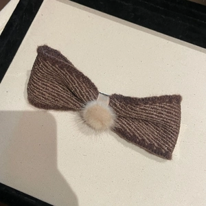 Brown knitted bow hair clip with plush pom-pom and subtle gold sparkles for girls