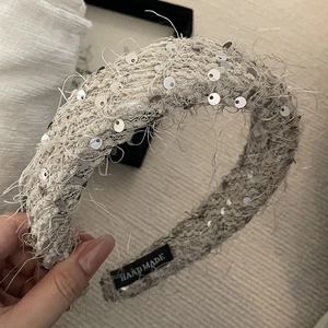 Detail of sequined tweed headband featuring fringe edges and a handmade cloth label