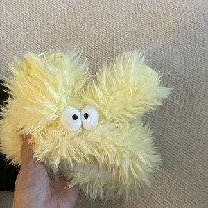Détail du bandeau monstre en peluche jaune avec texture douce et grands yeux rigolos