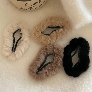 Set of four plush cloud hair clips in beige, khaki, coffee, and black on a white rug