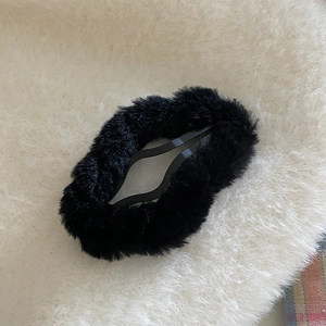Close-up of black plush cloud BB hair clip showing fuzzy texture and metal base mechanism