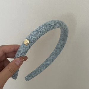 Detail of blue wool texture headband with elegant golden metal buckle decoration