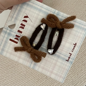 Dettaglio di fermagli per capelli in maglia marrone con cristallo a cuore su cartoncino