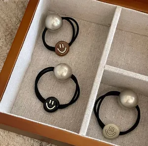 Detailed macro view of high-elastic hair ties with pearl beads and smiley face charms