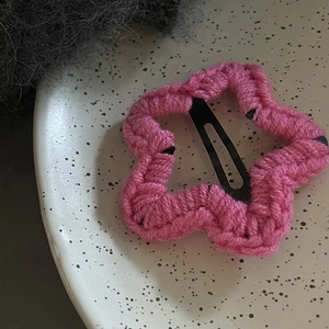 Pince à cheveux étoile en crochet rose sur assiette en céramique pour coiffure