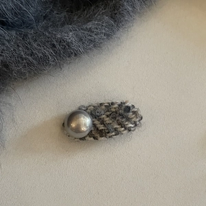 Elegant tweed hair clip with silver metallic sphere ornament on minimalist background