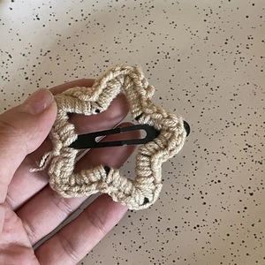 Gros plan détaillé d'une pince à cheveux étoile en crochet avec attache en métal noir