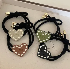 Close-up of heart-shaped elastic hair ties with Like engraving in multiple colors