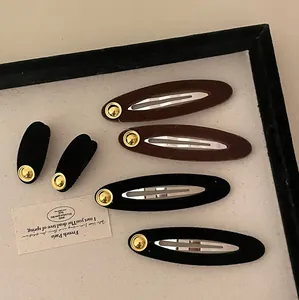 Detail von Vintage Samt Haarclips in Schwarz und Braun mit goldener Metallschnalle