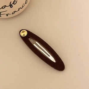 Detailansicht der Haarspange aus Kaffeestoff mit goldener Schnalle und silberner Feder