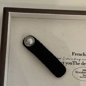 French vintage black velvet hair clip with a grey pearl on a wooden display tray