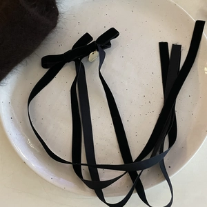 Elegant black velvet bow hair clip with long ribbons and golden pendant accessory