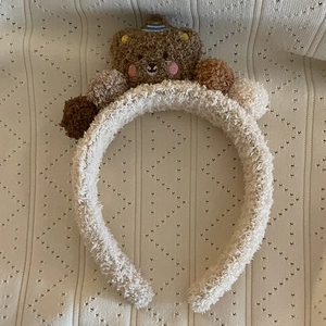 Serre-tête mignon en polaire beige avec ours en peluche marron et pompons colorés
