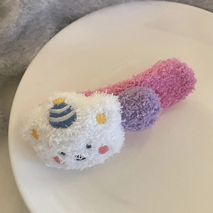 Vue macro détaillée d'une pince à cheveux en laine d'agneau avec alpaga et boules colorées