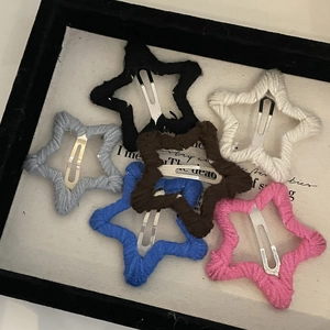 Gros plan de barrettes étoilées en laine tricotée de six couleurs sur un plateau