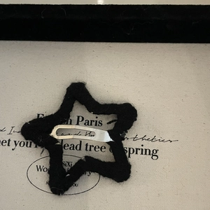 Barrette étoile en maille noire avec pince BB en métal argenté sur fond décoratif